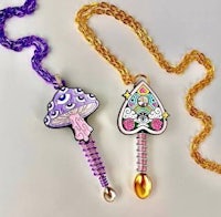 two necklaces with a purple mushroom and a gold chain